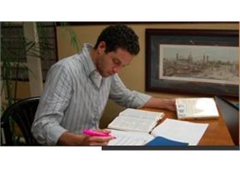 student studying with textbooks at a desk