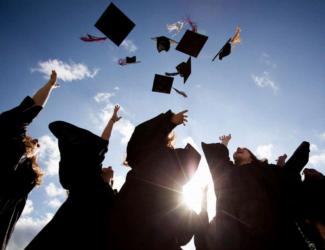 graduates tossing caps in the air under clear sky