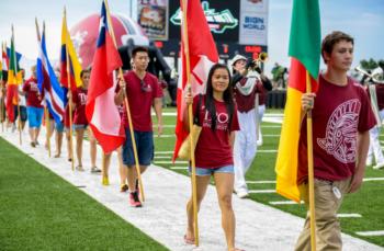 students walking with international flags on a field