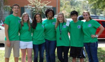 group of students in green t-shirts smiling