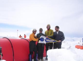 group holding a sign at a snowy location