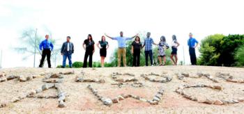 group of people standing behind rocks arranged to say 'welcome awc'