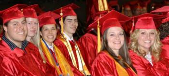 group of graduates in red caps and gowns smiling