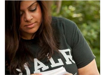 student reading with 'UALR' on shirt