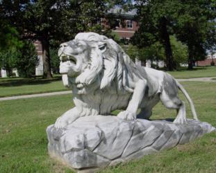 sculpture of a roaring lion on a grassy area