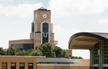 clock tower with partial view of a campus building