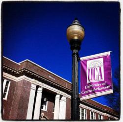 street lamp with 'university of central arkansas' banner, blue sky