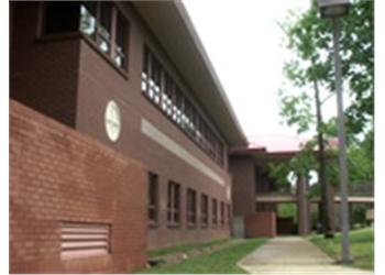 brick building with walkway and trees