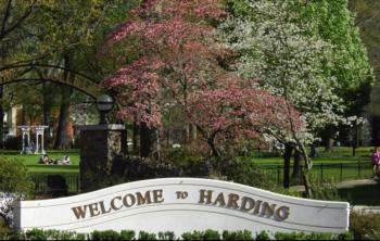 sign reading 'welcome to harding' with flowering trees