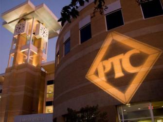 illuminated building with 'ptc' logo at dusk