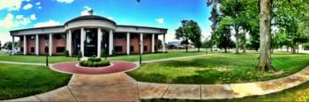 panoramic view of an institution's front facade with green lawns