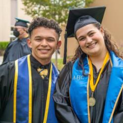 graduates smiling in commencement regalia