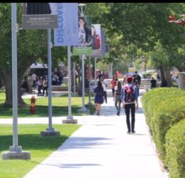 students walking on a college campus pathway