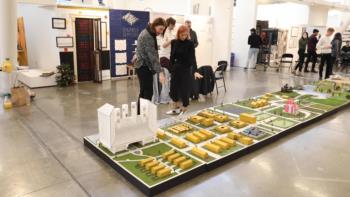 students examining architectural models on a large table