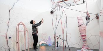 artist creating an installation with various shapes and lines