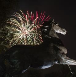 horse statue with fireworks in the background