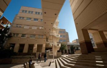 pedestrians walking through a campus plaza with modern buildings