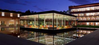 illuminated modern building at dusk with reflections on water