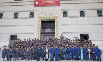 large group of graduates in front of a temple