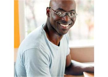 smiling man in glasses sitting indoors