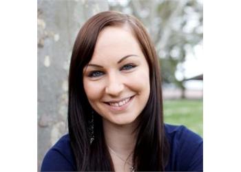 smiling woman with blue top outdoors