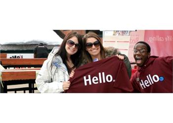 three people holding shirts with 'hello' text