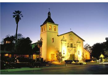 historic building at dusk with lit windows and bell tower