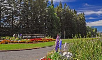 entrance sign with 'Sonoma State University' surrounded by flowers