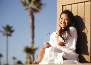 student smiling while leaning on a wall