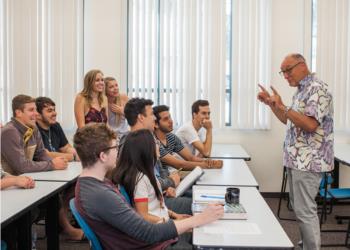 students listening to a professor in a classroom