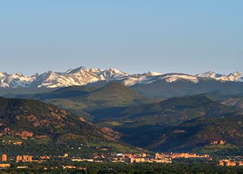 scenic view of a mountain range behind campus buildings