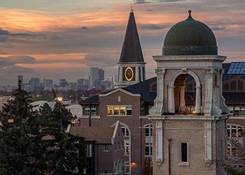 close-up of tower clock and cityscape at dusk