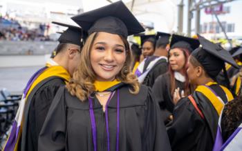 graduate beaming in cap and gown