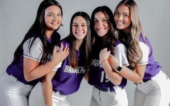 softball team members posing in uniforms