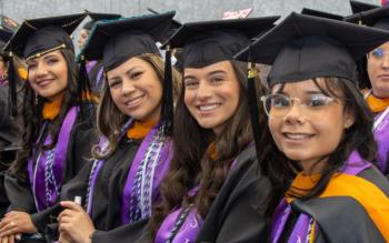 graduates smiling in commencement attire