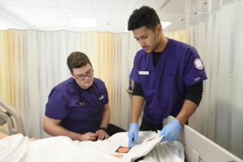 nursing student examining patient mannequin