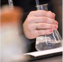 close-up of a hand holding a flask in a lab setting