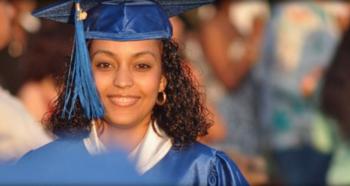 graduating student smiling in cap and gown