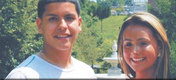 two students smiling with a campus building in background