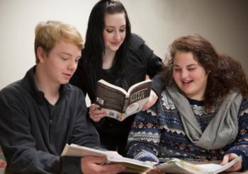 three students reading books together