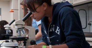 student using a microscope in lab