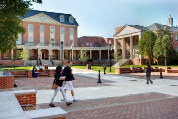 two students walking on campus plaza