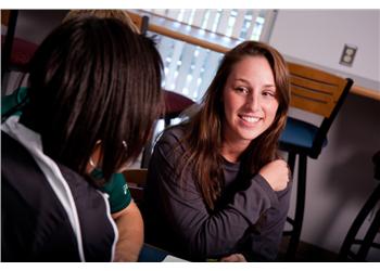 two students smiling during a conversation