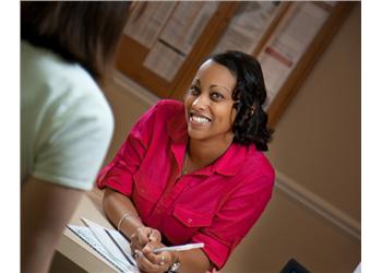 smiling woman engaged in discussion at a desk