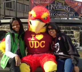 two people with a mascot reading 'i love udc'