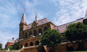 historic campus building with flag