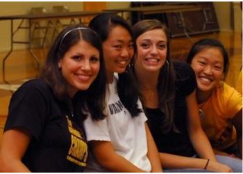 four smiling students posing indoors