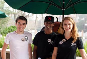 three students under an umbrella at 'flagler'