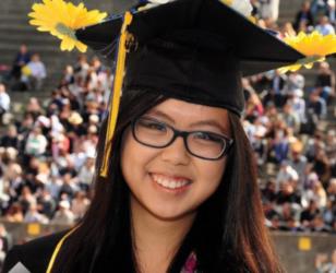 graduated student smiling with flowers on cap