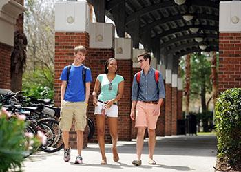 students walking under an archway on campus